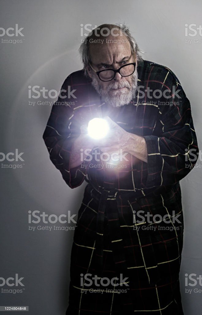 anxious-suspicious-old-man-pointing-flashlight-in-dark-cellar-picture-id1224504848.jpg