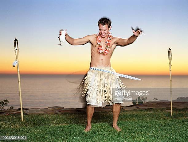 young-man-in-grass-skirt-playing-with-plastic-hoop-picture-id200120018-001.jpg